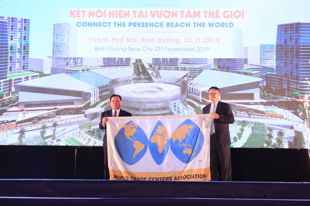 Đại diện Hiệp hội Trung tâm thương mại thế giới trao cờ cho đại diện chủ đầu tư Trung tâm thương mại thế giới Bình Dương - Ảnh: BÁ SƠN